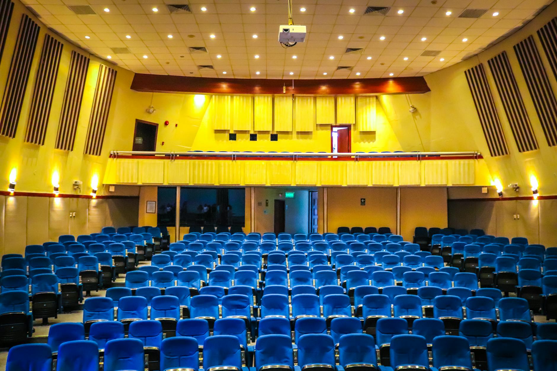 empty auditorium with blue seats and yellow walls